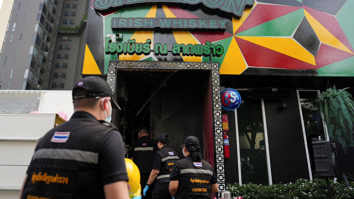 Forensic police officials arrive to inspect the site of a deadly fire at a pub in Bangkok, Thailand, July 13, 2026. REUTERS/Arnun Chonmahatrakool