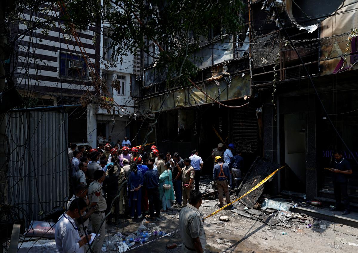 Firefighters and police officers stand at the site after a fire at a hotel in New Delhi, India, June 3, 2026. REUTERS/Adnan Abidi
