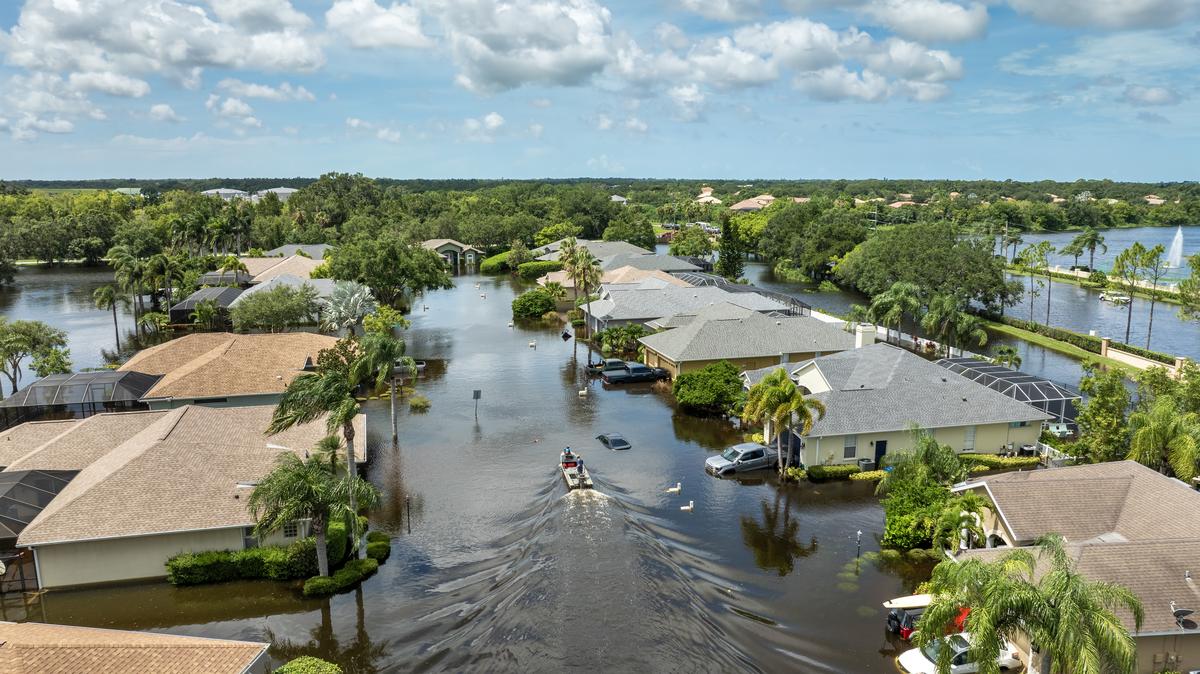 Hurricane Debby flooded street in Sarasota, Florida. Victims boating on rainfall flood waters between rural homes in residential area. 