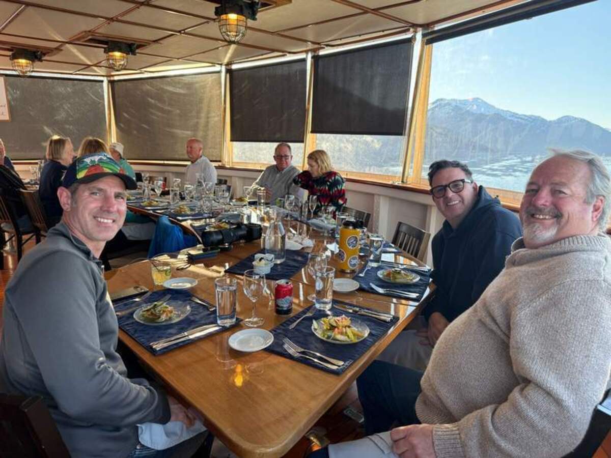 Dining with incredible views on the Mist Cove fantail. Shown here (L-R): Chris Taylor, Tom Mesereau, and Hunter McIntosh. Photo credit: Mimi Slawoff 