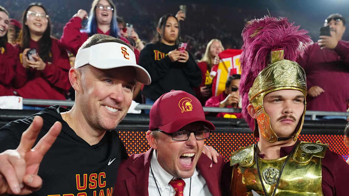  Nov 29, 2025; Los Angeles, California, USA; Southern California Trojans head coach Lincoln Riley (left) poses with Spirit of Troy marching band director James Vogel (center) and mascot Tommy Trojan after the game against the UCLA Bruins at United Airlines Field at Los Angeles Memorial Coliseum. Mandatory Credit: Kirby Lee-Imagn Images | Kirby Lee-Imagn Images 