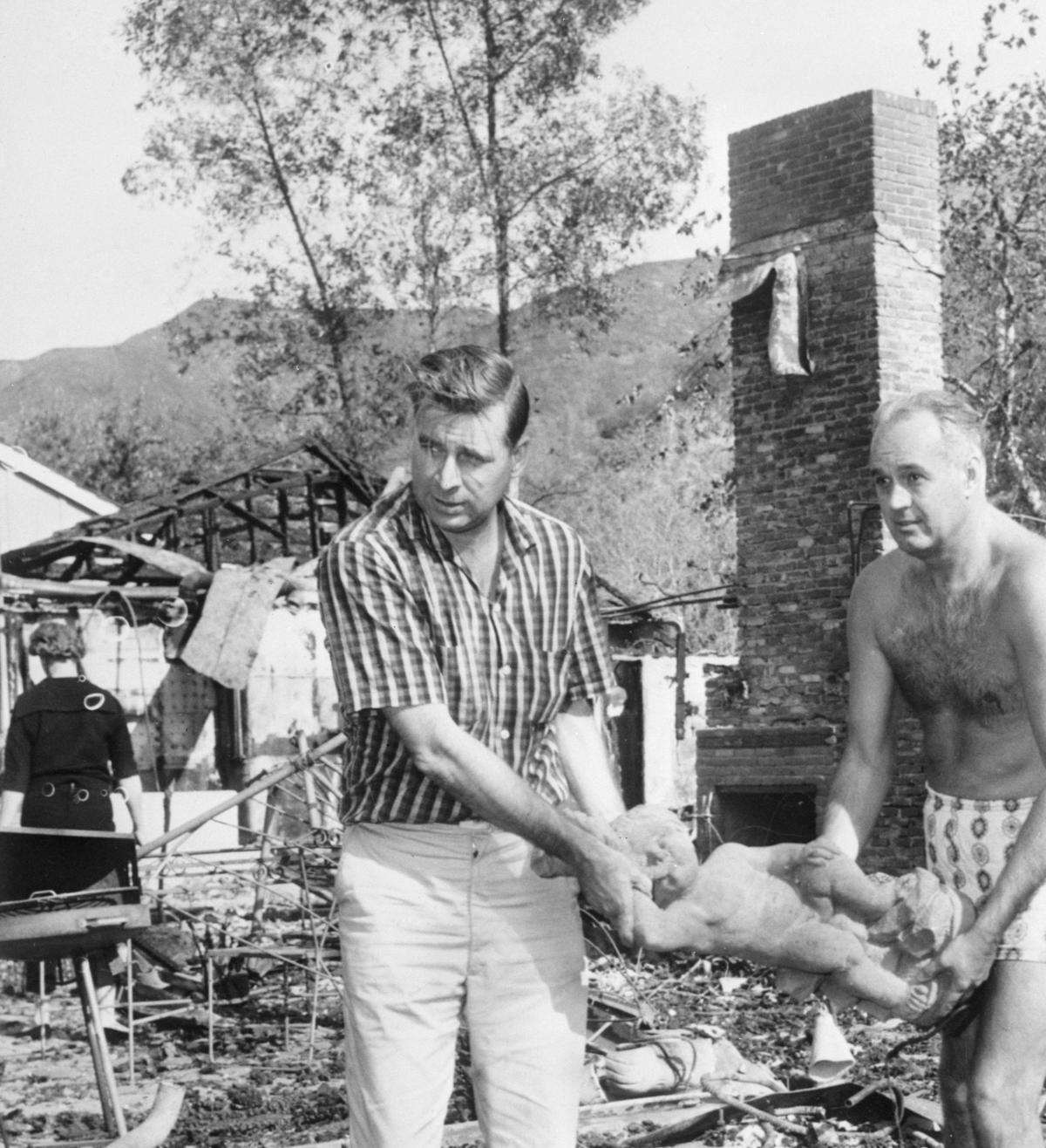 11/8/1961-Bel Air, CA- Television writer, Gene Roddenberry and attorney, Frank Swann, remove a statue from the burned-out home of TV producer, Leon Benson. The house was one of more than 250 burned in a disastrous brush fire that swept through the areaBettmann Archives