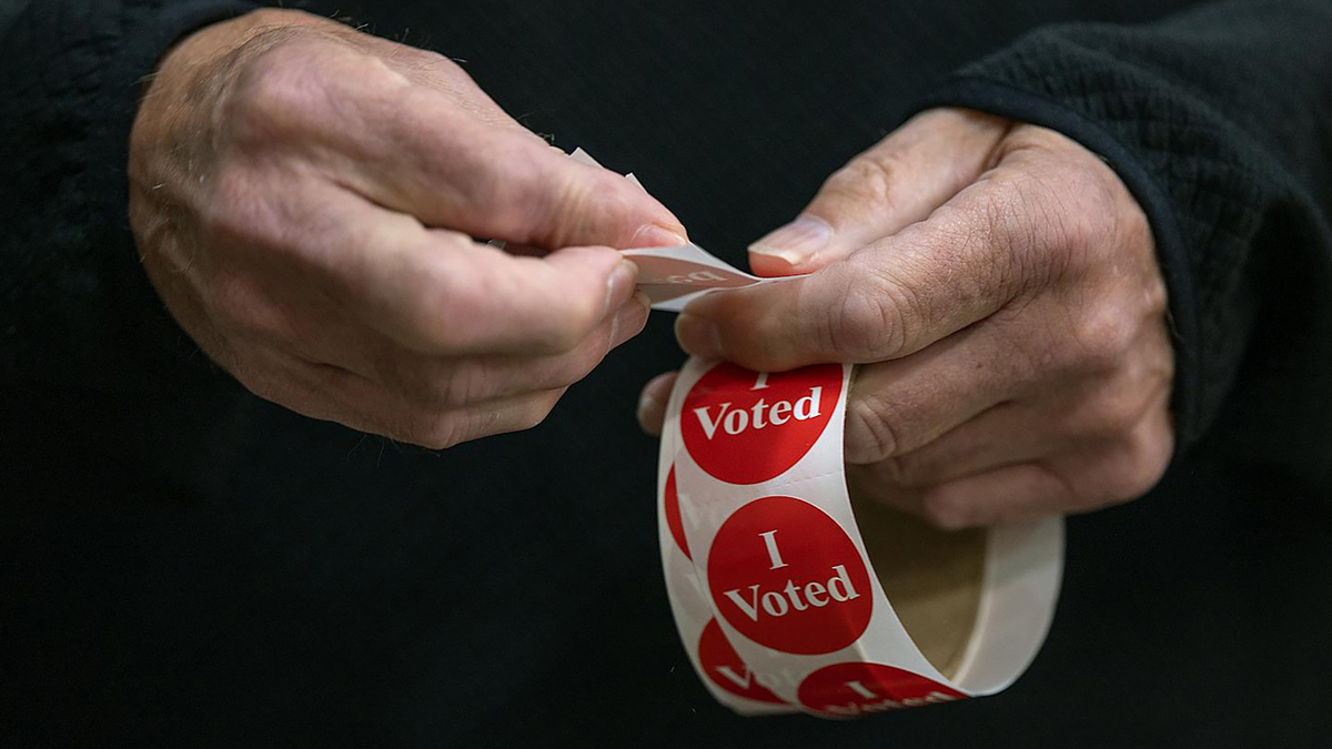 An election volunteer hands out "I Voted" stickers on Nov. 5, 2024, in Lakeville, Minnesota. (Elizabeth Flores/The Minnesota Star Tribune/TNS)