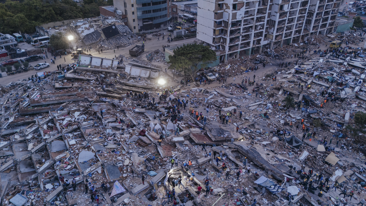 Rescuers search under lights at a group of collapsed residential buildings in La Guaira, Venezuela, June 30, 2026. After devastating twin earthquakes flattened entire residential neighborhoods last week, experts fear the official death toll of 1,719 could be a serious undercount. (Adriana Loureiro Fernandez/The New York Times)