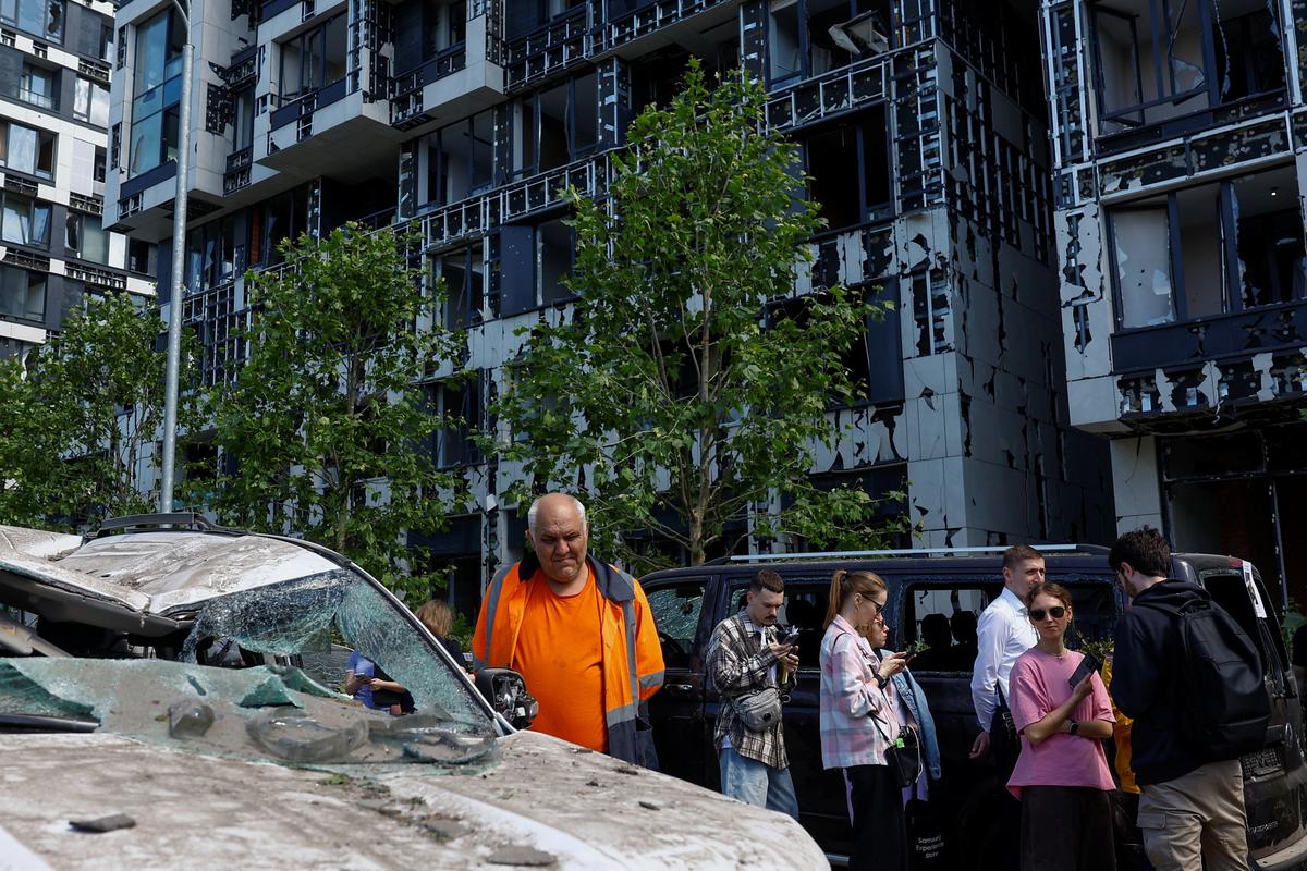 Residents gather outside an apartment building damaged during Russian missile and drone strikes, amid Russia's attack on Ukraine, in Kyiv, Ukraine June 2, 2026. REUTERS/Valentyn Ogirenko