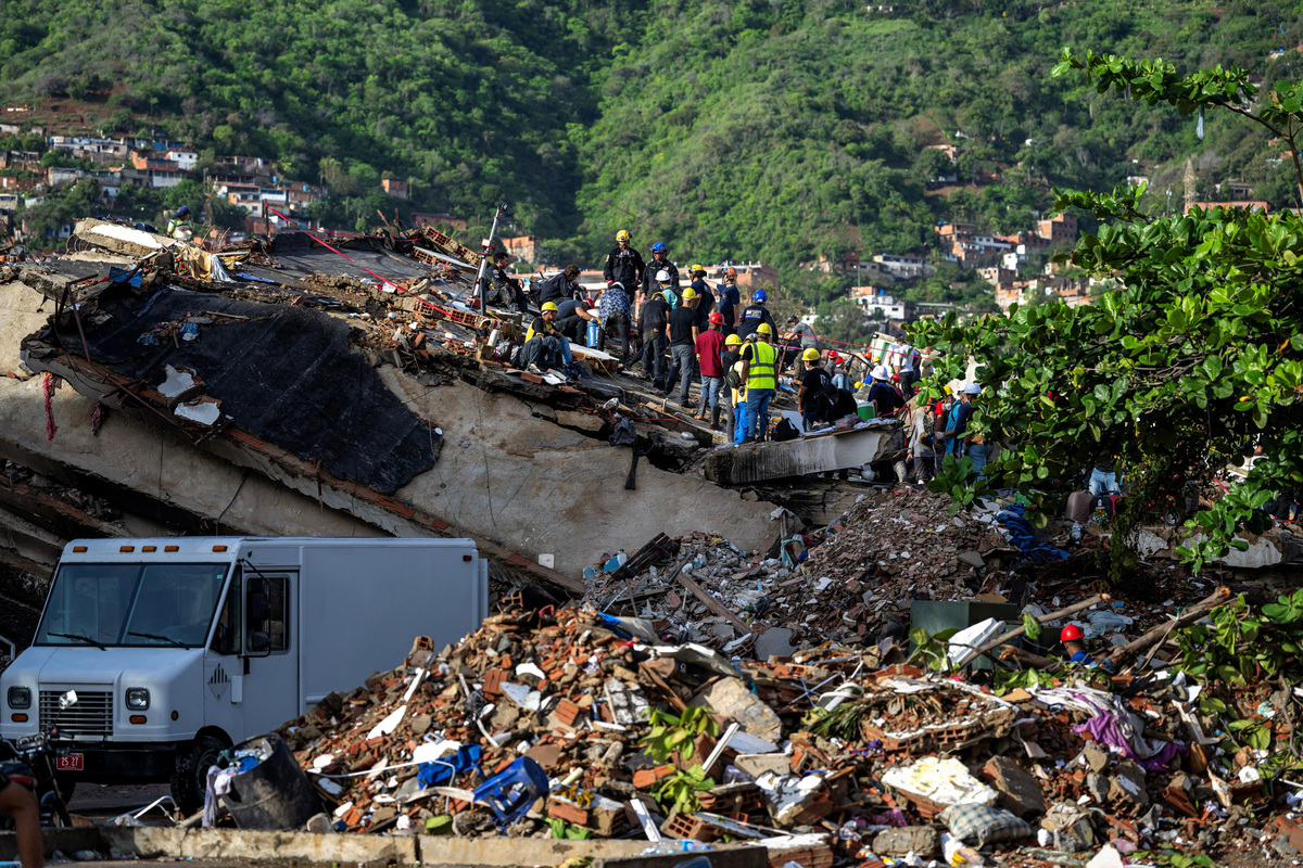 Rescuers and volunteers help to find survivors in the rubble of a collapsed building in Caraballeda, La Guaira state, Venezuela, on June 30, 2026, following the June 24 twin earthquakes. MIGUEL MEDINA/Pool via REUTERS