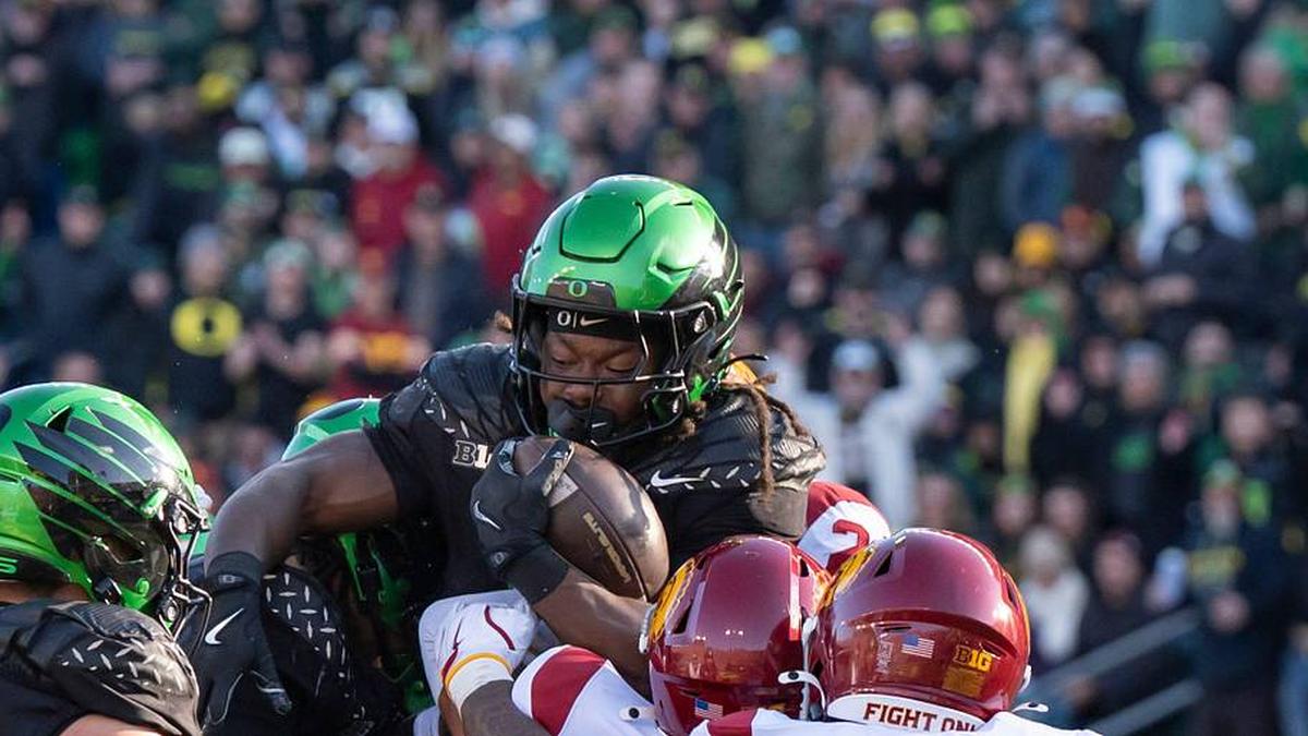  Oregon running back Noah Whittington is picked up by the offense and defense as the Oregon Ducks host the USC Trojans on Nov. 22, 2025, at Autzen Stadium in Eugene, Oregon. | Ben Lonergan/The Register-Guard / USA TODAY NETWORK via Imagn Images 