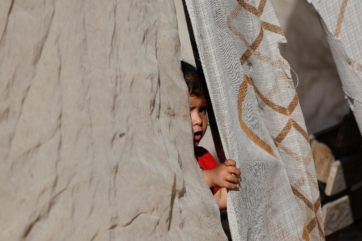 A girl peeks outside a tent at al-Khan al-Ahmar near Jericho, in the Israeli-occupied West Bank, May 19, 2026. REUTERS/Mohammed Torokman