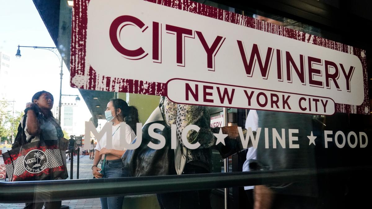Clientes esperan e fila para presentar pruebas de vacunación antes de ingresar al City Winery el jueves, 24 de junio del 2021, en la ciudad de Nueva York. Comensales que deseen beber vino, cenar y disfrutar de música en vivo en el restaurant de City Winery en Nueva York deben mostrar prueba de vacunación contra el coronavirus para poder entrar. Pero eso no es requerido ene la mayoría de los otros restaurantes en la ciudad. Ni en los locales de City Winery en el resto de Estados Unidos. (AP Foto/Frank Franklin II)