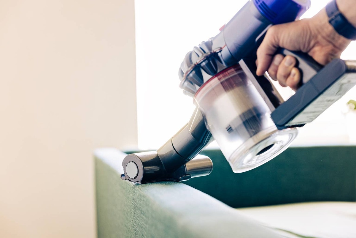  A person using a handheld vacuum.