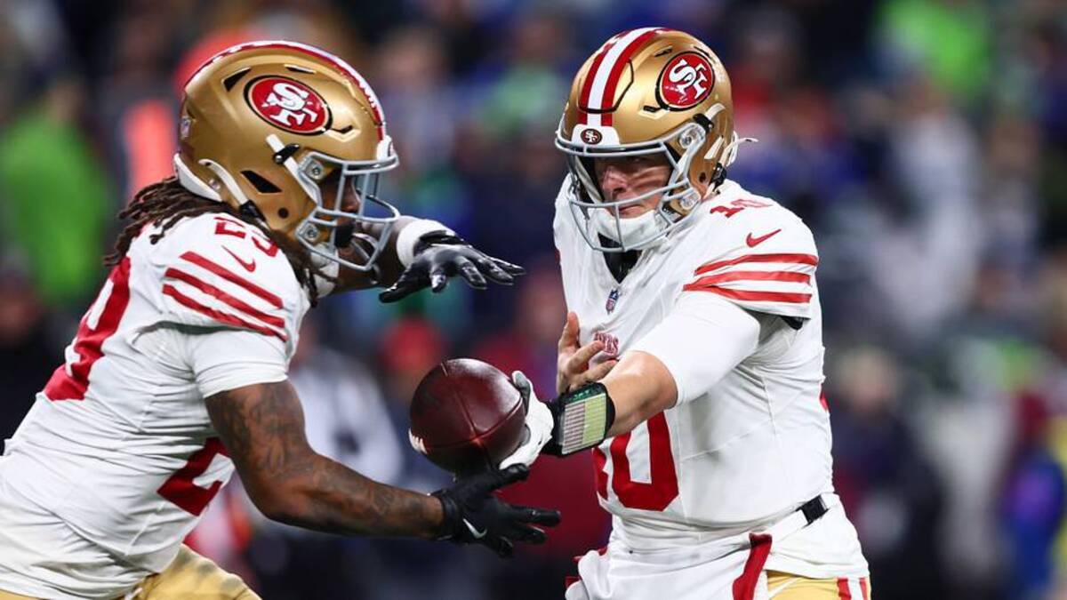  Jan 17, 2026; Seattle, WA, USA; San Francisco 49ers quarterback Mac Jones (10) hands off to running back Jordan James (29) against the Seattle Seahawks during the second half in an NFC Divisional Round game at Lumen Field. Mandatory Credit: Kevin Ng-Imagn Images | IMAGN IMAGES via Reuters Connect 