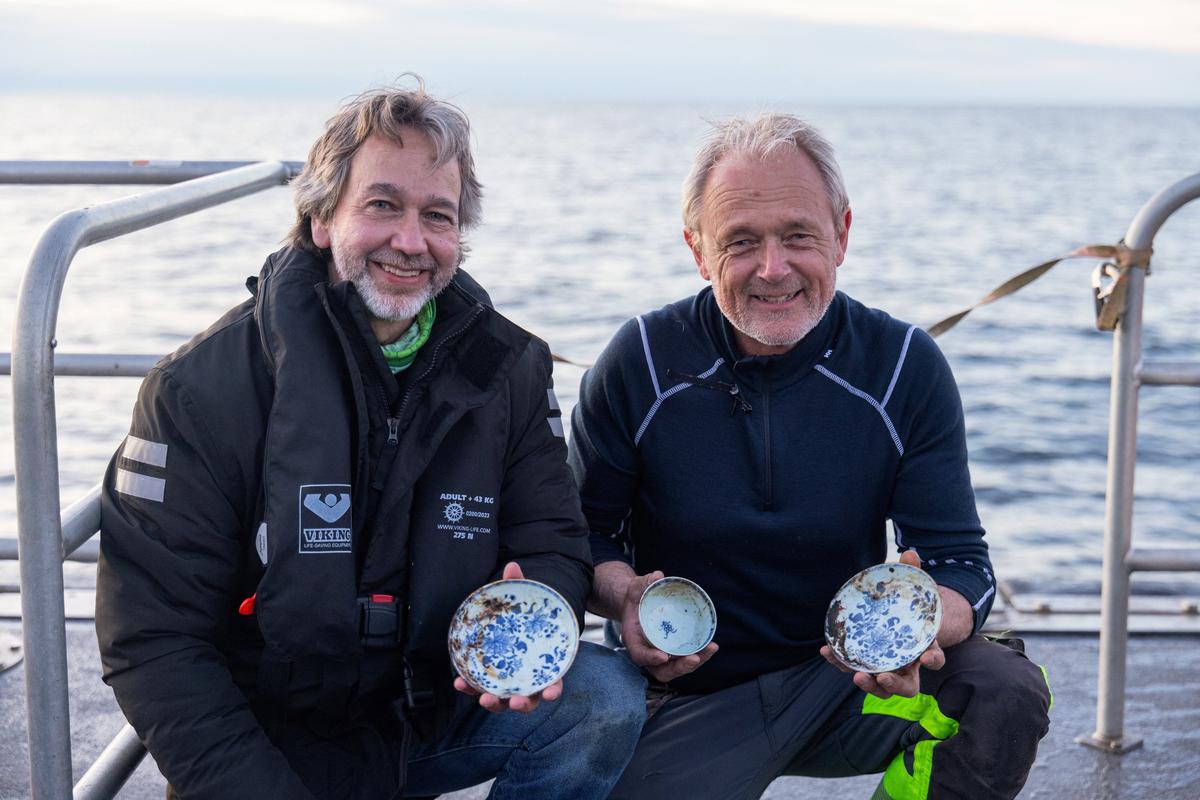 Crew members pose with a trove of Chinese porcelain from a recently discovered 18th-century shipwreck off the coast of Norway, at the Skagerrak Sea in this undated handout picture. Sindre Kinnerod/Handout via REUTERS
