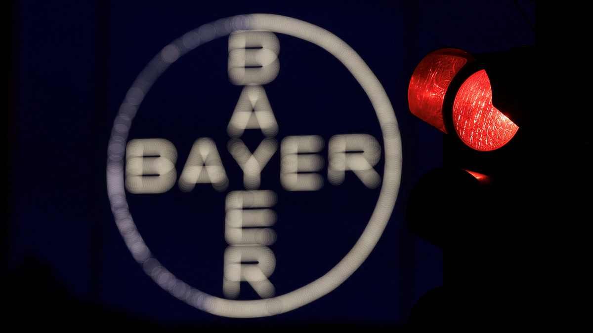 The 120 metres high Bayer Cross, logo of German pharmaceutical and chemical maker Bayer AG, consisting of 1710 LED glass bulbs, is seen next to a red traffic light in Leverkusen, Germany, September 23, 2023.  REUTERS/Wolfgang Rattay