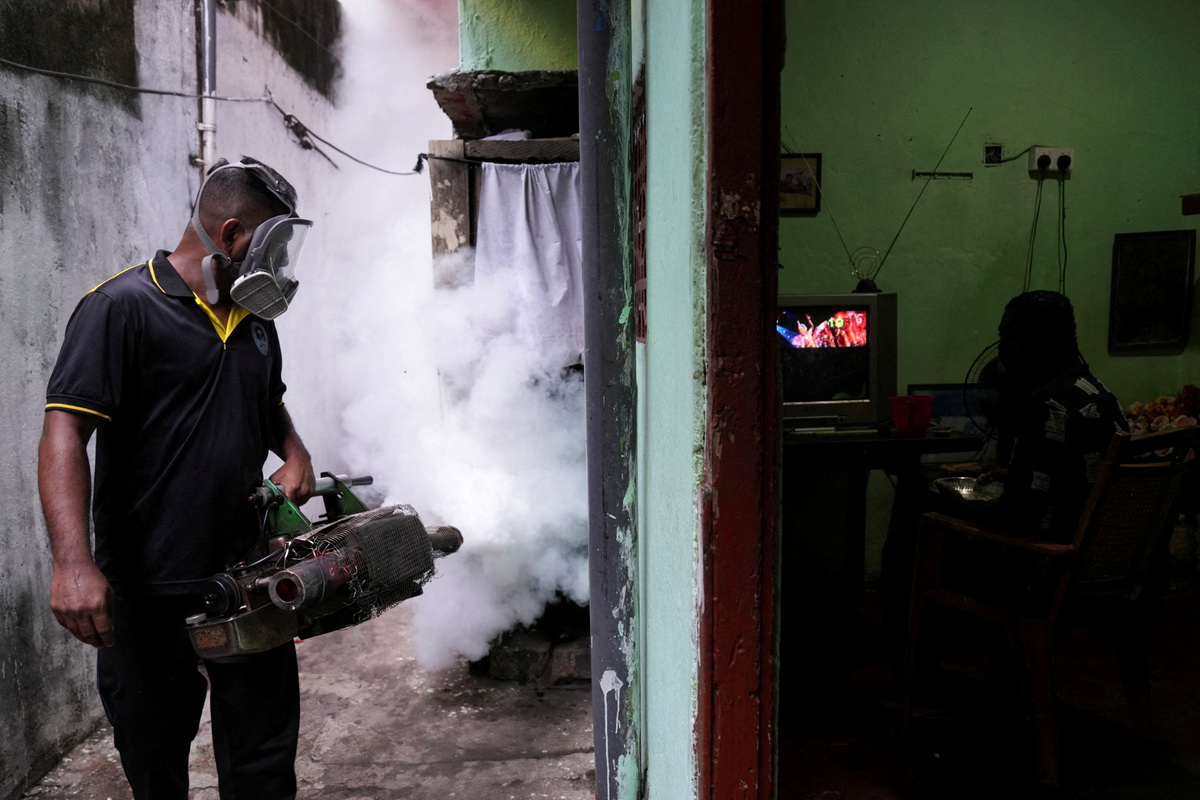 A resident watches television as a health worker from the Medical Officer of Health (MOH) department fumigates an area during a mosquito control programme in Colombo, Sri Lanka, June 19, 2026. REUTERS/Thilina Kaluthotage     TPX IMAGES OF THE DAY