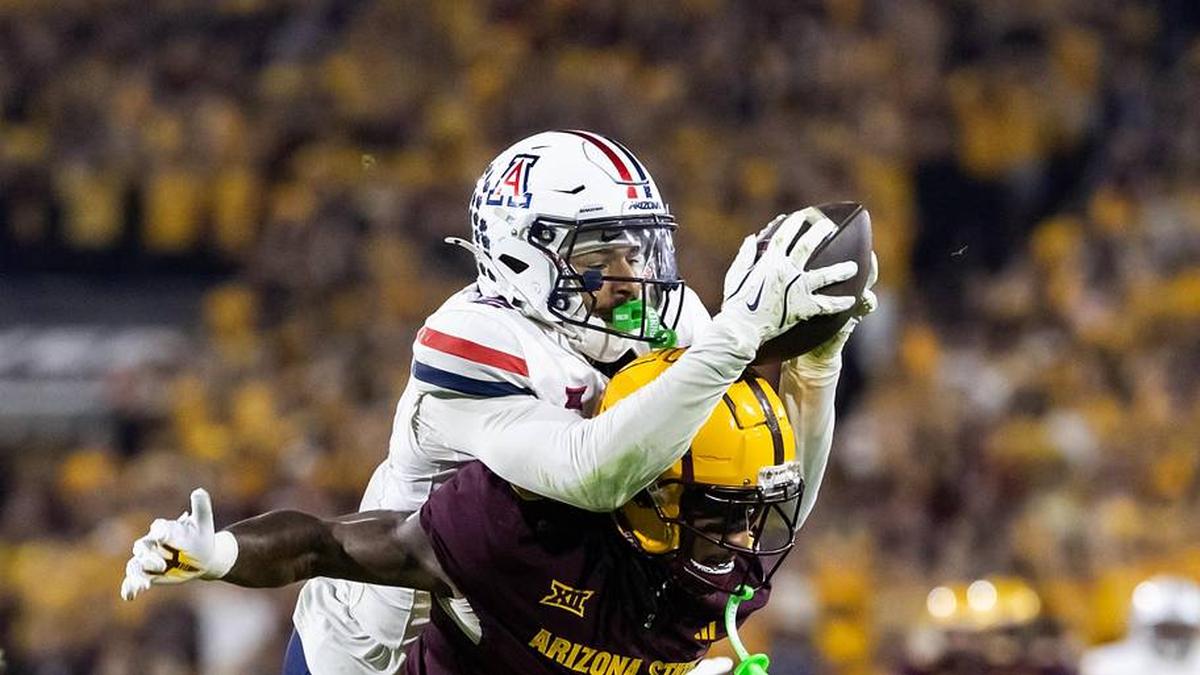  Nov 28, 2025; Tempe, Arizona, USA; Arizona Wildcats defensive back Treydan Stukes (2) intercepts the ball against Arizona State Sun Devils wide receiver Jaren Hamilton (16) in the second half during the 99th Territorial Cup at Mountain America Stadium. Mandatory Credit: Mark J. Rebilas-Imagn Images | Mark J. Rebilas-Imagn Images 