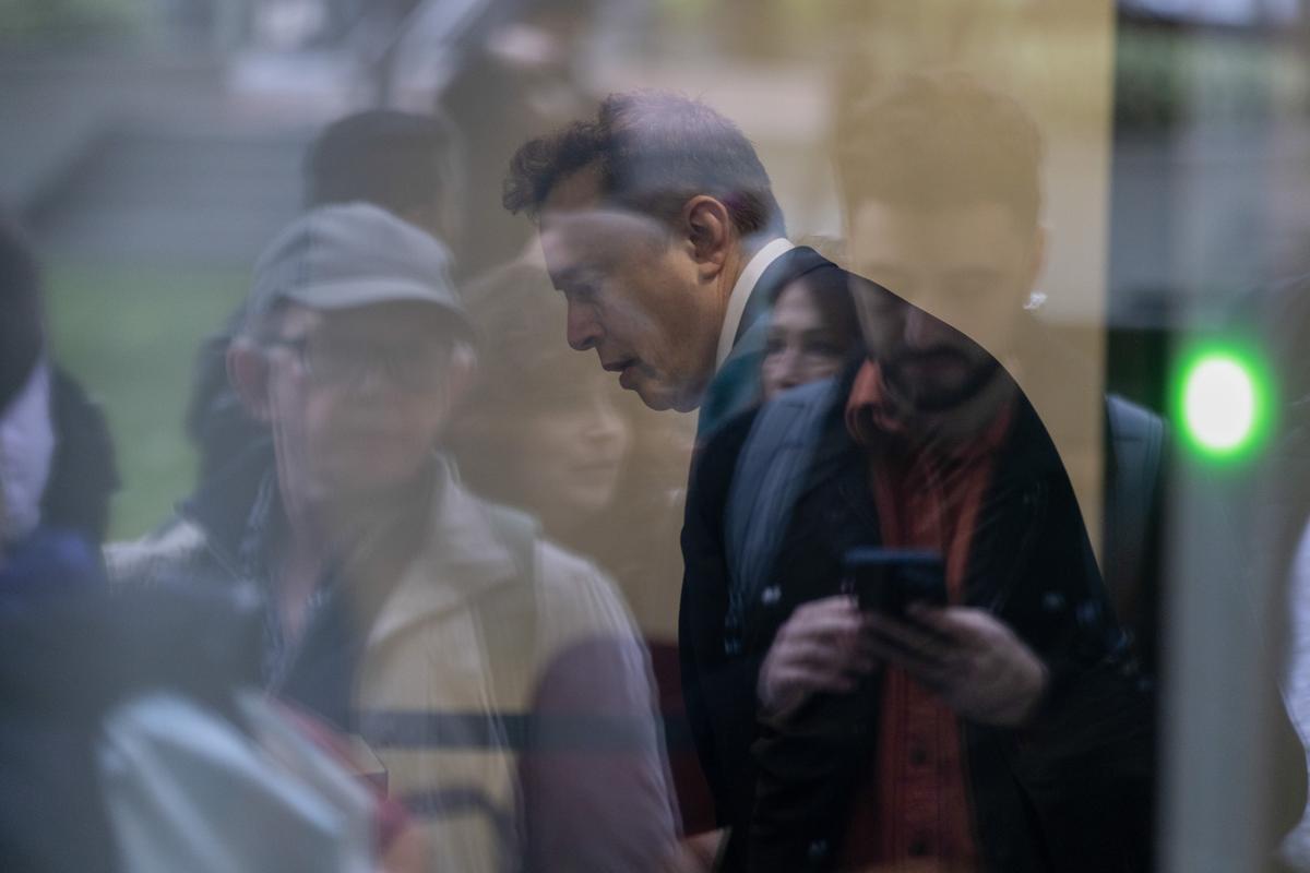 Seen through reflections in glass, Elon Musk arrives at The Ronald V. Dellums Federal Courthouse in Oakland, Calif., the venue for his lawsuit against OpenAI, on Tuesday, April 28, 2026. The blockbuster trial could reshape one of the artificial intelligence industry's most important companies and shift the course of the AI race. (Brennan Smart/The New York Times)