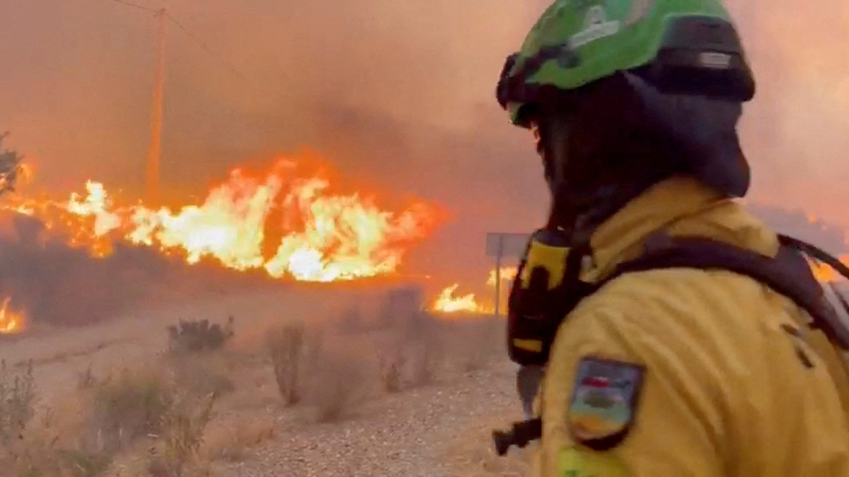 An emergency worker looks on during a wildfire in Almeria, Spain, in this screengrab taken from a handout video released on July 10, 2026. @Plan_INFOCA via X/Handout via REUTERS