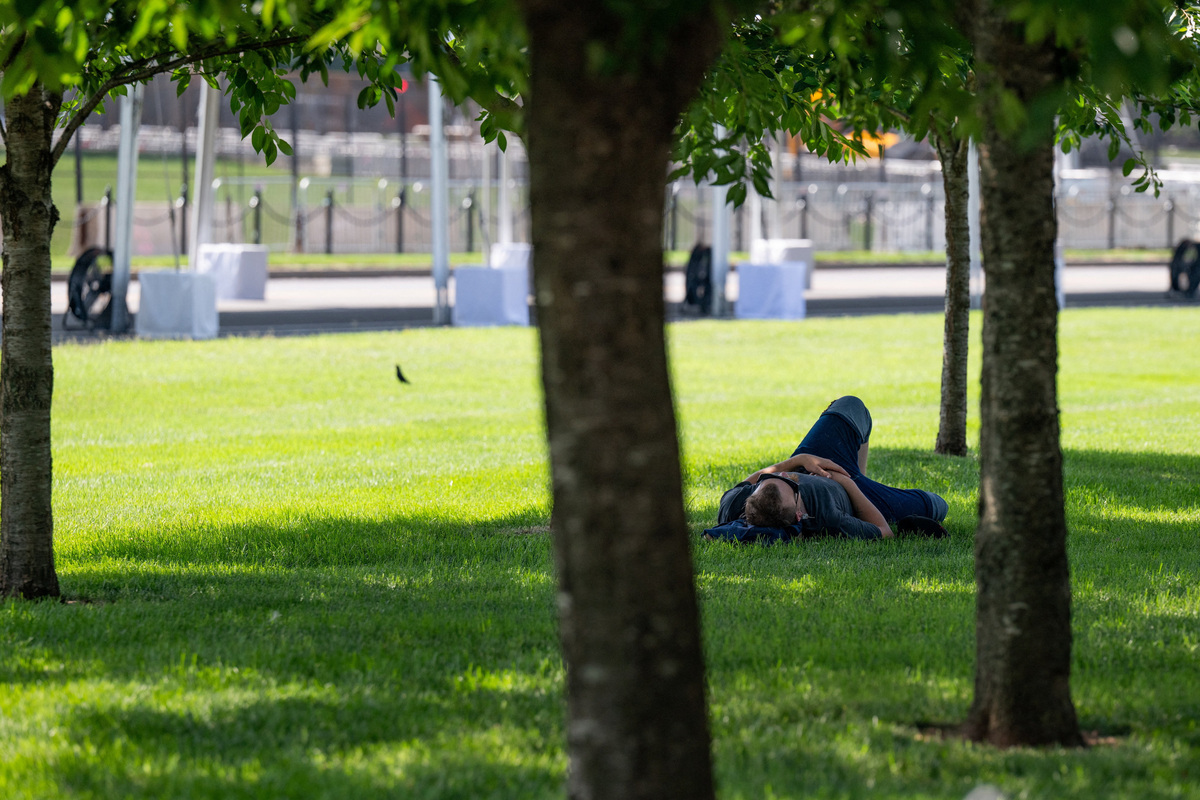 A man lies down under trees as excessive heat hits Washington, D.C., U.S., July 1, 2026. REUTERS/Annabelle Gordon