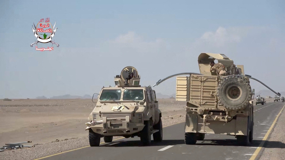 Yemeni government fighters shown driving vehicles over Houthi opponents 