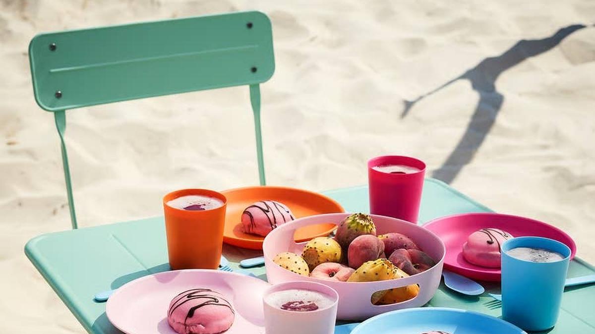 Picnic on beach with different pastel plates and tray.