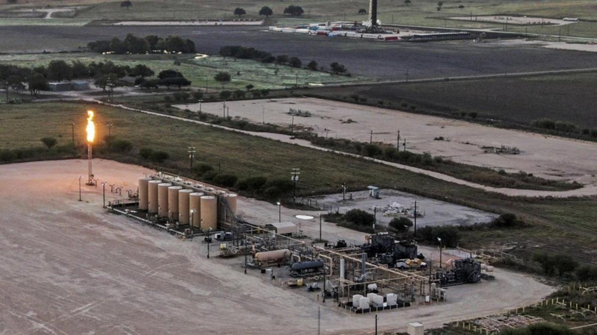 An aerial photo made with a drone shows gasses burning off near oil storage tanks and a drilling rig near Karnes City, Texas. Photo by TANNEN MAURY / EPA