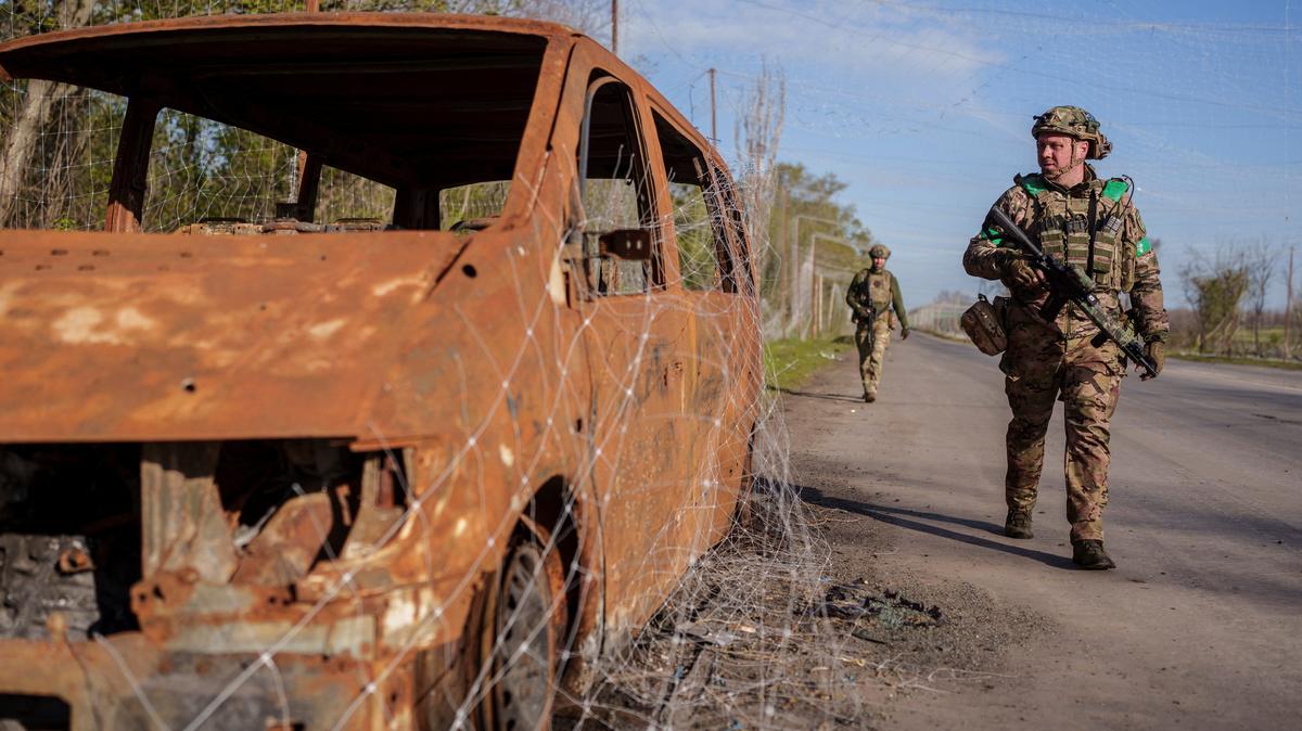 Servicemen of the consolidated Brigade 'Khyzhak' of the Ukrainian Patrol Police Department walk along a street under an anti-drone net in the town of Druzhkivka, amid Russia's attack on Ukraine, in Donetsk region, Ukraine April 28, 2026. REUTERS/Serhii Korovainyi