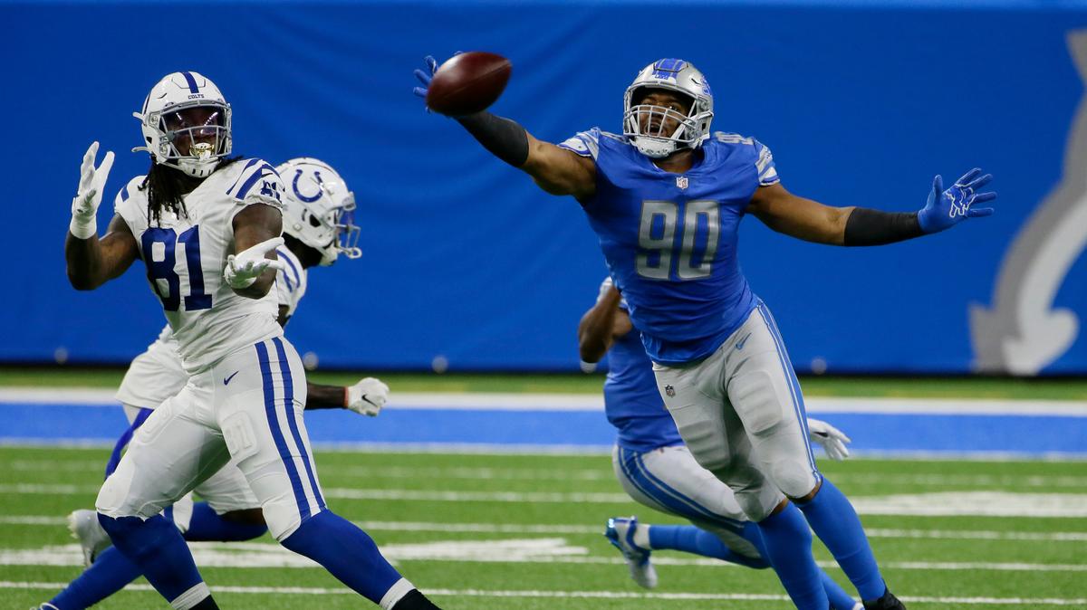 El defensive end de los Lions Trey Flowers (der.) intercepta un pase a al tight end de los Colts de Indianápolis, Alie Cox, en el partido celebrado el 1ro de noviembre de 2021 en Detroit.