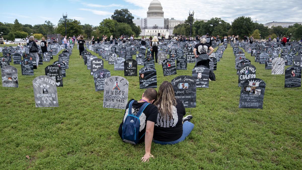 People who lost relatives to a drug overdose sit among imitation graves set up by the Trail of Truth, near the U.S. Capitol in Washington, D.C., on Sept. 24, 2022. (Stefani Reynolds/AFP/Getty Images/TNS)