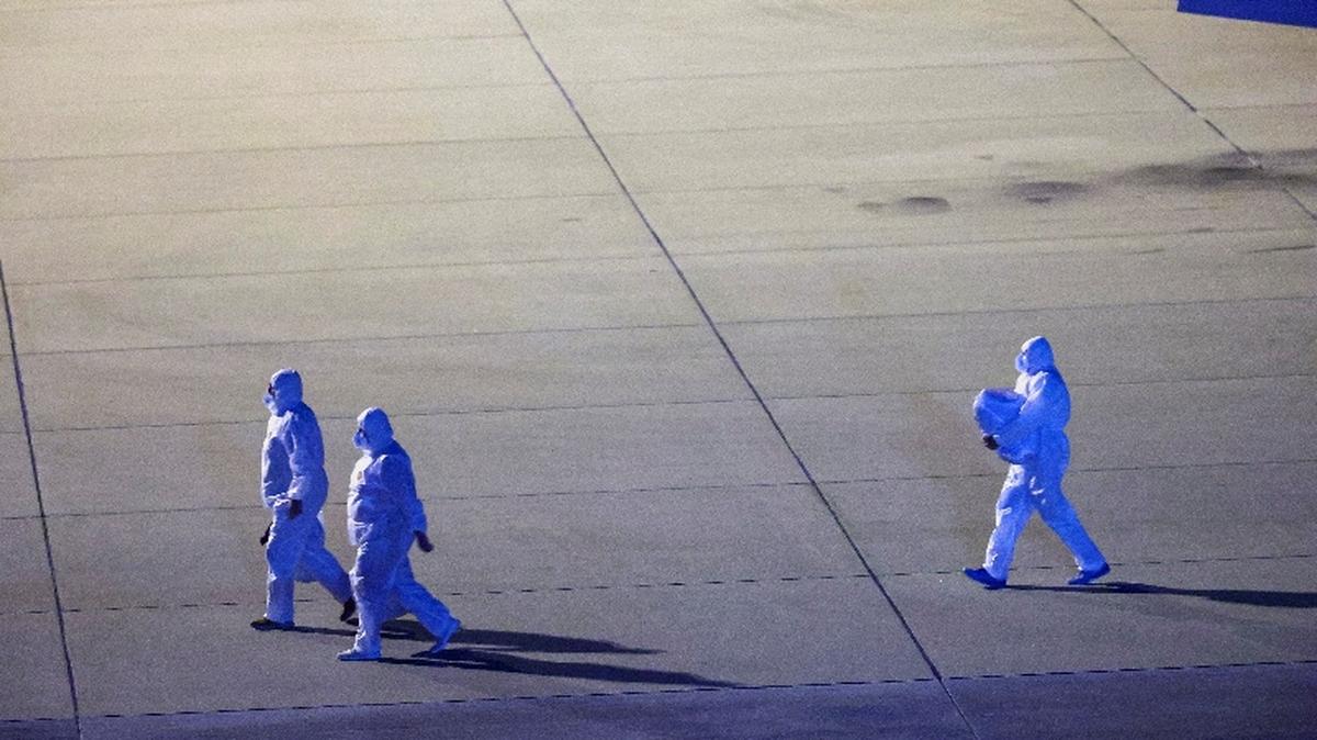 FILE PHOTO: Personnel in hazmat suits walk near a plane carrying passengers evacuated from the cruise ship MV Hondius, which was affected by a hantavirus outbreak, after it landed at the Eindhoven Air Base in Eindhoven, Netherlands May 12, 2026. REUTERS/Piroschka van de Wouw/File Photo