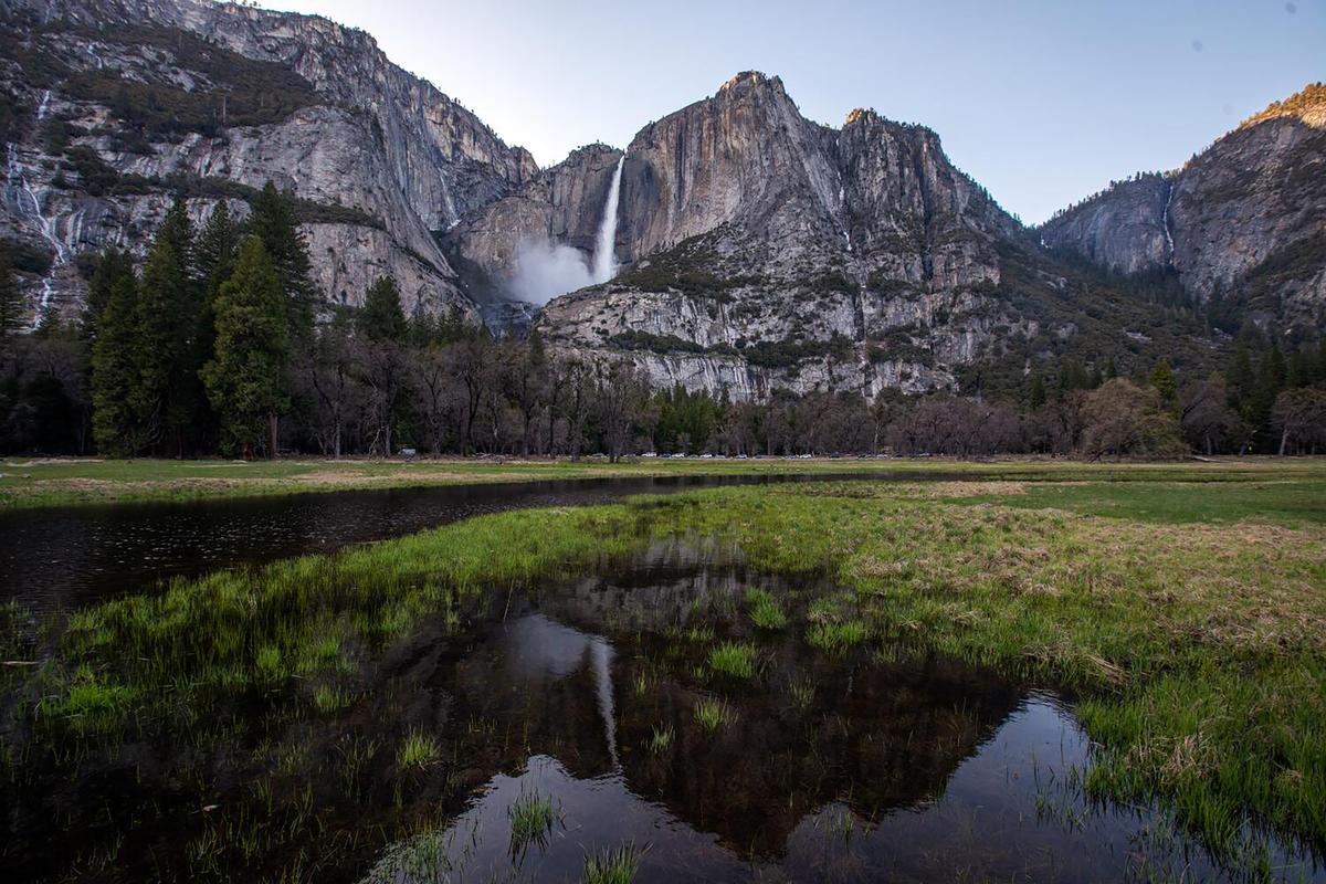 The waterfall is reflected in water in the meadow in the Yosemite Valley as the snowpact melts on April 26, 2023, in Yosemite National Park.