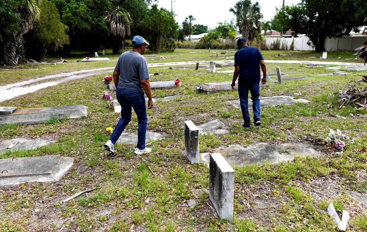 Family members of those buried at the Old Memphis Cemetery, a predominantly African-American cemetery in Palmetto, inspect their loved ones’ graves after 17 gravesites and several headstones were vandalized in Palmetto, Florida, U.S., May 14, 2026. Authorities say “Trump” and “DeSantis” were spray-painted in red across multiple tombs as police continue investigating the incident. REUTERS/Octavio Jones