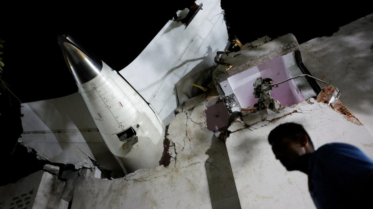 A person walks past debris at the crash site after an Air India aircraft, bound for London's Gatwick Airport, crashed during take-off from an airport in Ahmedabad, India June 12, 2025. REUTERS/Adnan Abidi
