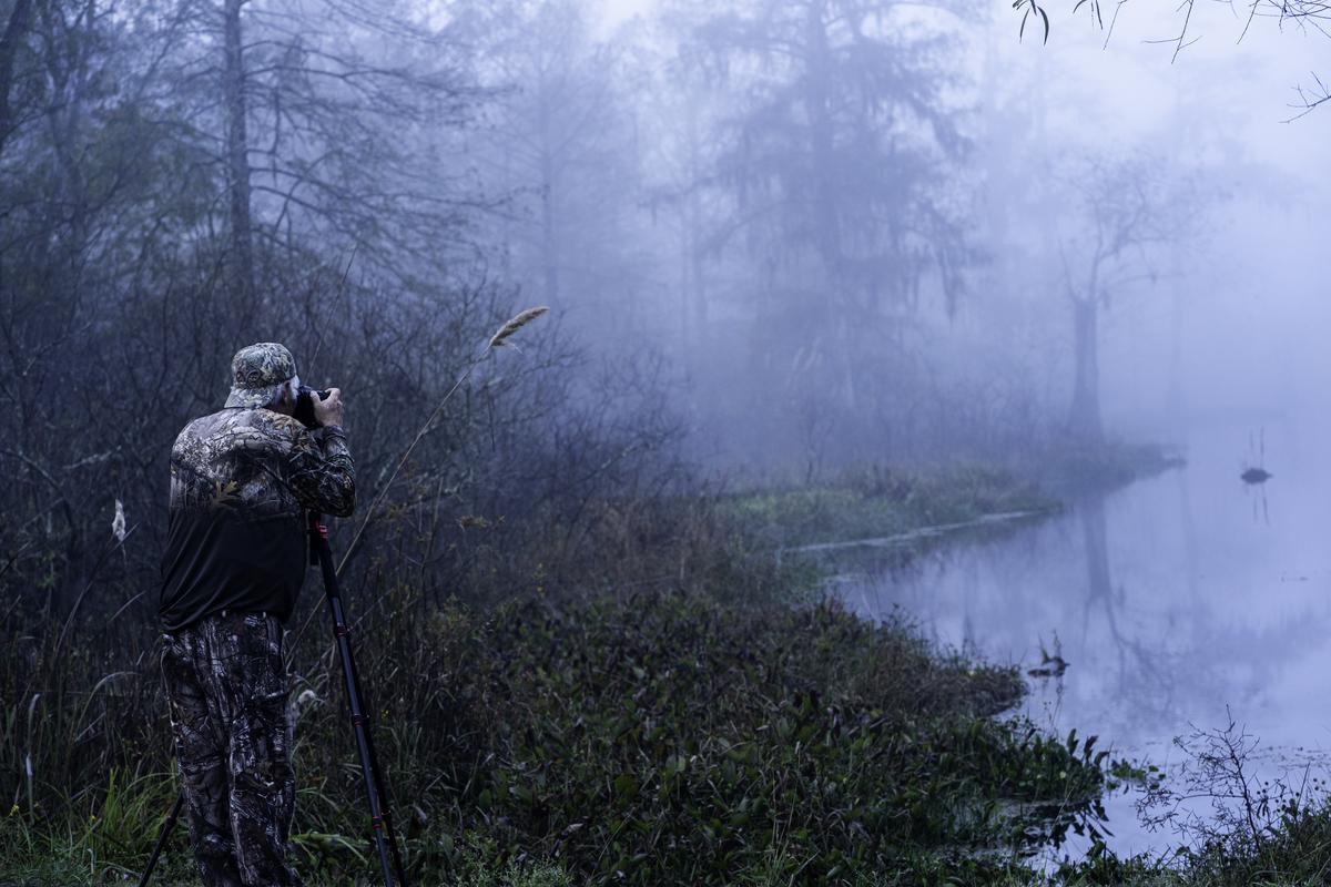  A man photographs a misty morning from the edge of Lake Martin in Breaux Bridge, Louisiana, on November 21, 2020. 