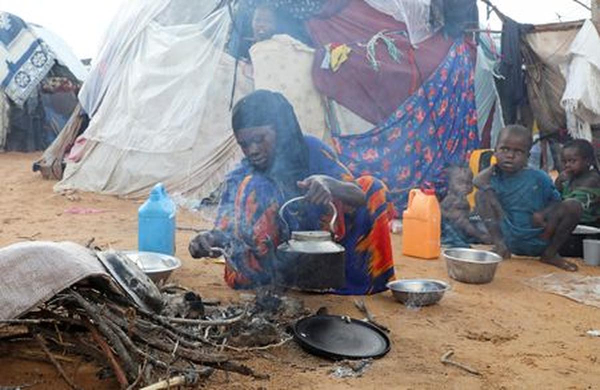 An internally displaced woman prepares breakfast outside their makeshift shelter during a visit by World Food Programme’s Assistant Executive Director for Programme Operations, Matthew Hollingworth (not in the photo), to assess the knock on effects from the escalation in the Middle East, alongside drought and sharp cuts in humanitarian funding that are worsening hunger, in Kahda district of Mogadishu, Somalia May 7, 2026. REUTERS/Feisal Omar