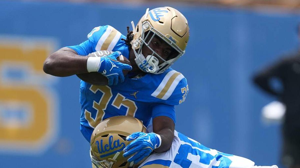  May 2, 2026; Pasadena, CA, USA; UCLA Bruins running back Karson Cox (33) is tackled by defensive back Logan Hirou (35)during the spring game at Rose Bowl. Mandatory Credit: Kirby Lee-Imagn Images | Kirby Lee-Imagn Images 