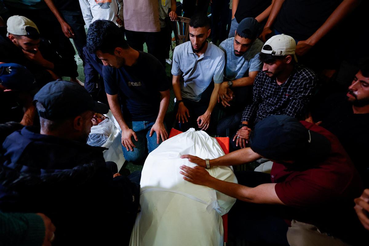 People mourn over a body identified by mourners as Hamas' military wing commander Mohammad Odeh who was killed in an Israeli strike on Tuesday, during a funeral, in Gaza City, May 27, 2026. REUTERS/Mahmoud Issa