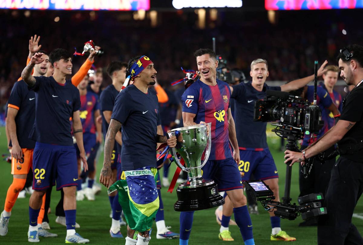  Barcelona's Brazilian forward #11 Raphinha and Barcelona's Polish forward #09 Robert Lewandowski hold the trophy as Barcelona's players celebrate winning the 2025-2026 Spanish League after the Spanish league football match between FC Barcelona and Real Madrid CF at Camp Nou Stadium in Barcelona on May 10, 2026. (Photo by Josep LAGO / AFP via Getty Images) Photo by Josep LAGO / AFP via Getty Images