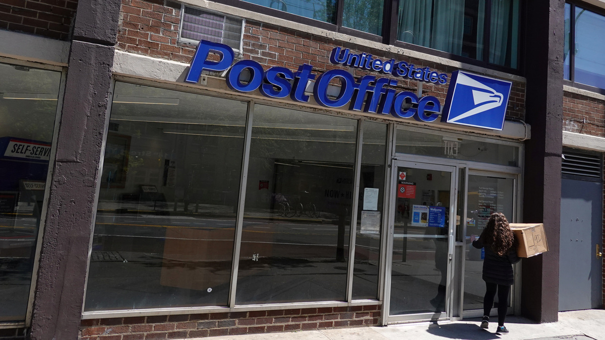 A person enters a United States Postal Service (USPS) Post Office in Manhattan, New York City, in 2022.