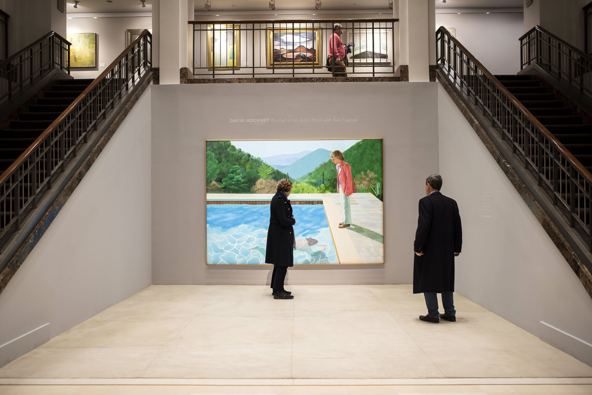 FILE -- Patrons view David Hockney's "Portrait of an Artist (Pool with Two Figures)", the day before it was auctioned for $90 million, at Christie's in New York, Nov. 14, 2018. Hockney, whose colorful figurative paintings were both conservative and iconoclastic, defying the dominant abstract schools of the mid-20th century, died at home in London on June 11, 2026. He was 88. (Karsten Moran/The New York Times)
