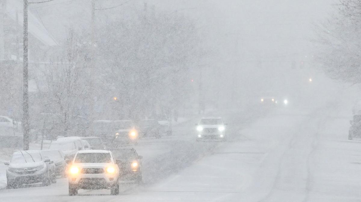 Traffic moves slowly though heavy snow.