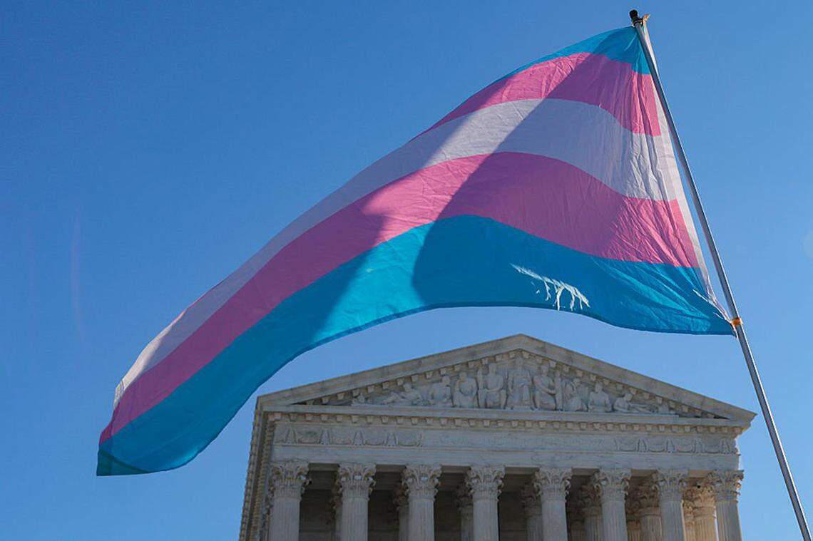 Protesters supporting transgender athletes competing in women’s sports wave a transgender pride flag outside the U.S. Supreme Court on Jan. 13 in Washington. On Monday, March 2, the court issued a temporary ruling allowing California parents to be informed if their children are transitioning at school.
