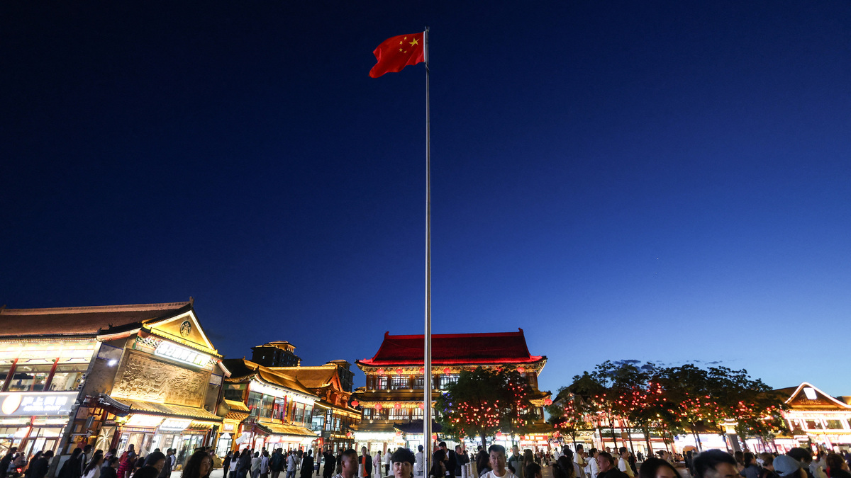 A Chinese national flag flies in the wind as people walk in the Dazhao Square in Hohhot, Inner Mongolia autonomous region, China, June 10, 2026. REUTERS/Maxim Shemetov