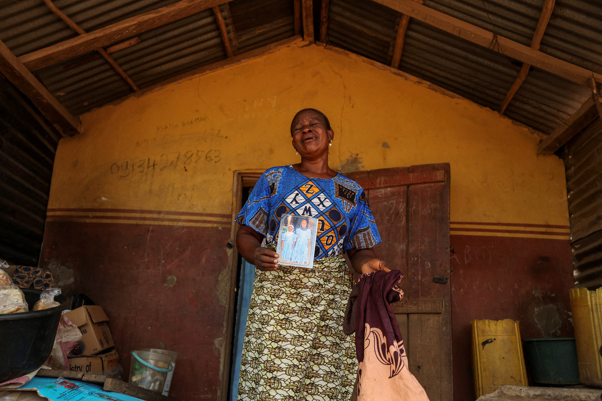 Aduke Balogun, whose daughter was among dozens of pupils and teachers abducted in a large-scale school attack in southwestern Nigeria, reacts while displaying her daughter's photograph and clothing after an interview with Reuters at her home in Yawota, Oyo State, Nigeria, June 2, 2026. REUTERS/Sodiq Adelakun