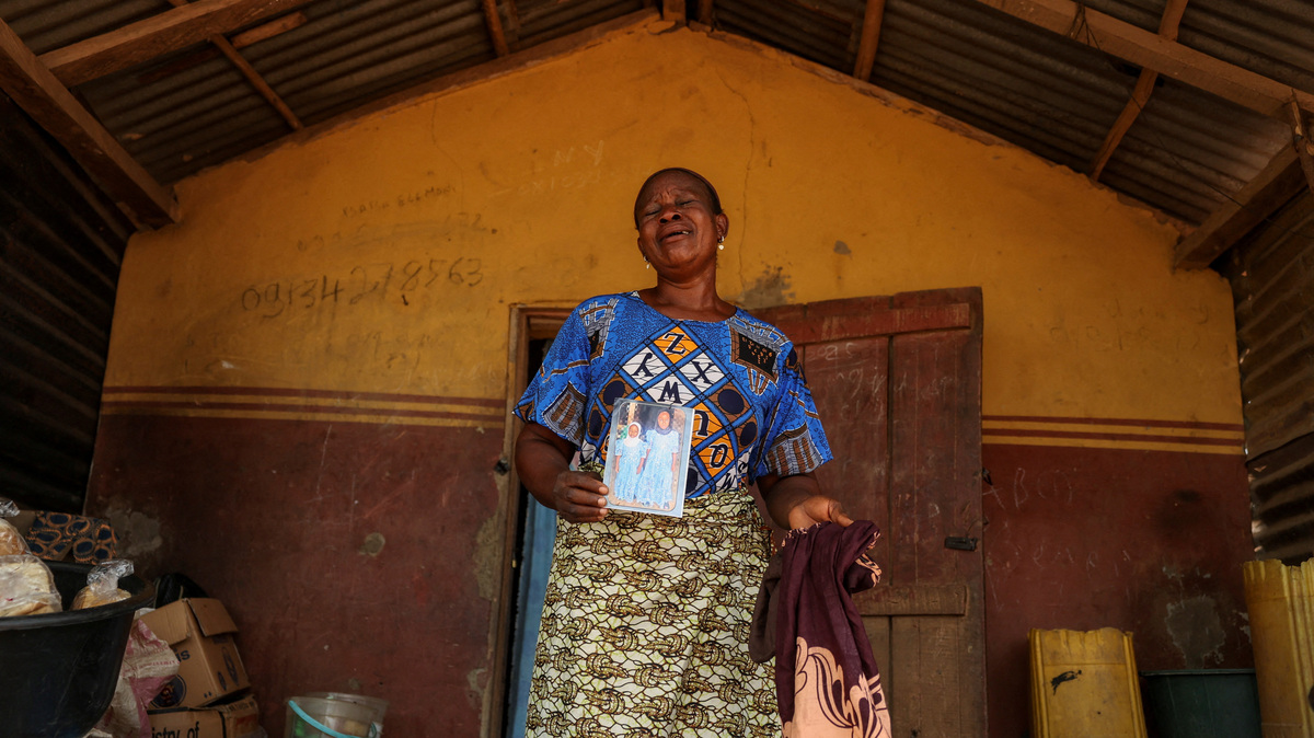 Aduke Balogun, whose daughter was among dozens of pupils and teachers abducted in a large-scale school attack in southwestern Nigeria, reacts while displaying her daughter's photograph and clothing after an interview with Reuters at her home in Yawota, Oyo State, Nigeria, June 2, 2026. REUTERS/Sodiq Adelakun