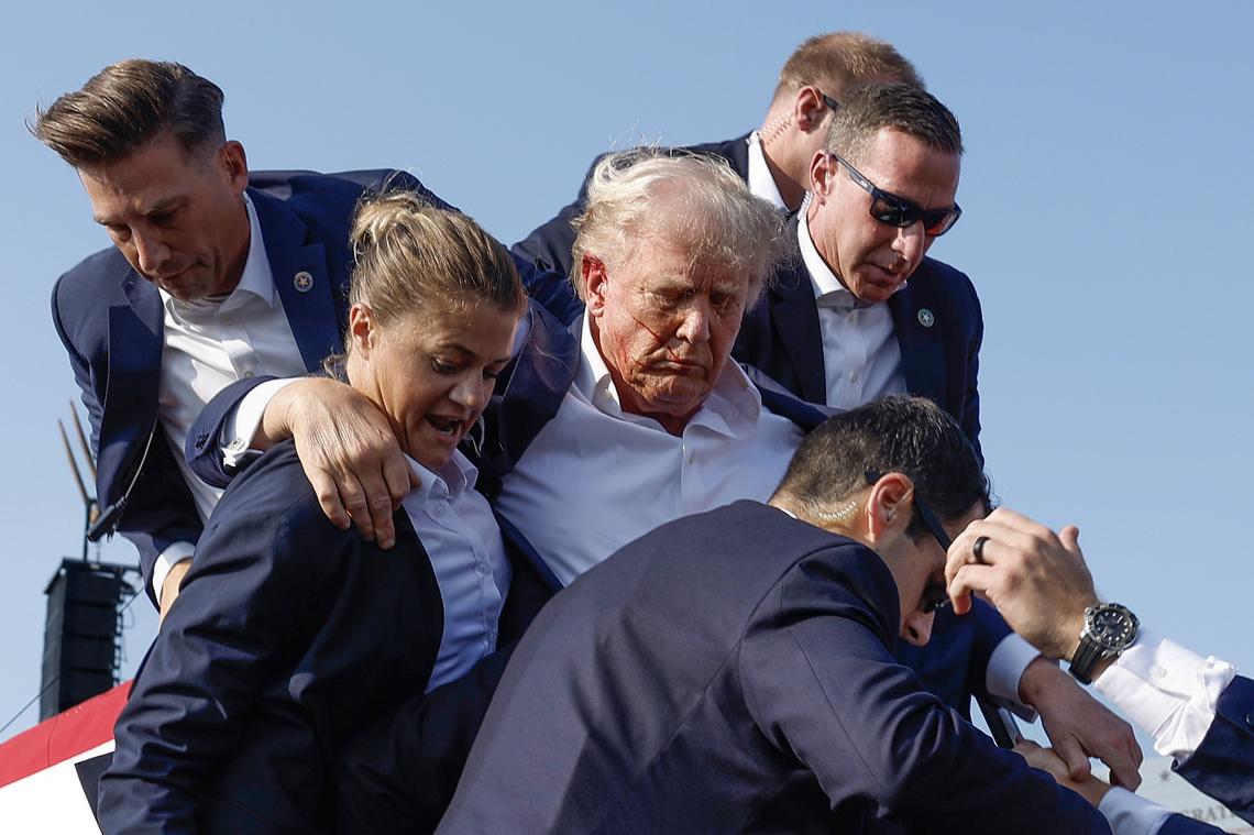 Donald Trump is rushed offstage by U.S. Secret Service agents after being grazed by a bullet during a presidential campaign rally on July 13, 2024, in Butler, Pennsylvania. 
