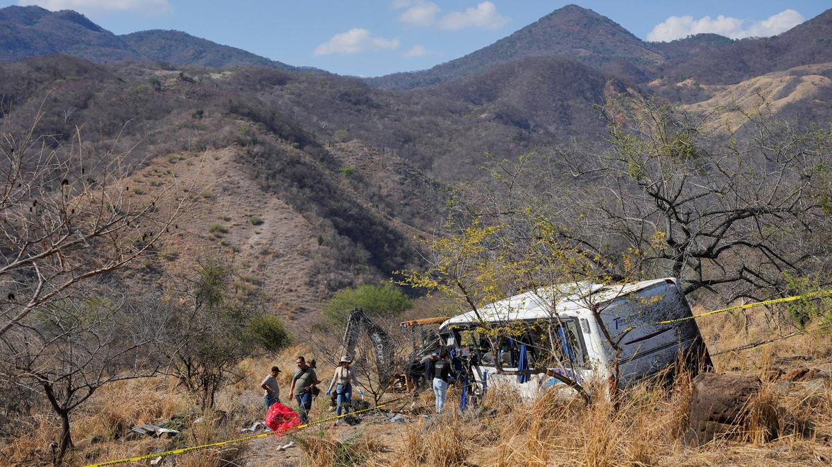 People and staff from the Nayarit Attorney General's office stand near the site where a tourist bus overturned, killing several people and injuring others near the town of Amatlan de Canas, in the western state of Nayarit, Mexico, May 1, 2026. REUTERS/Christian Ruano