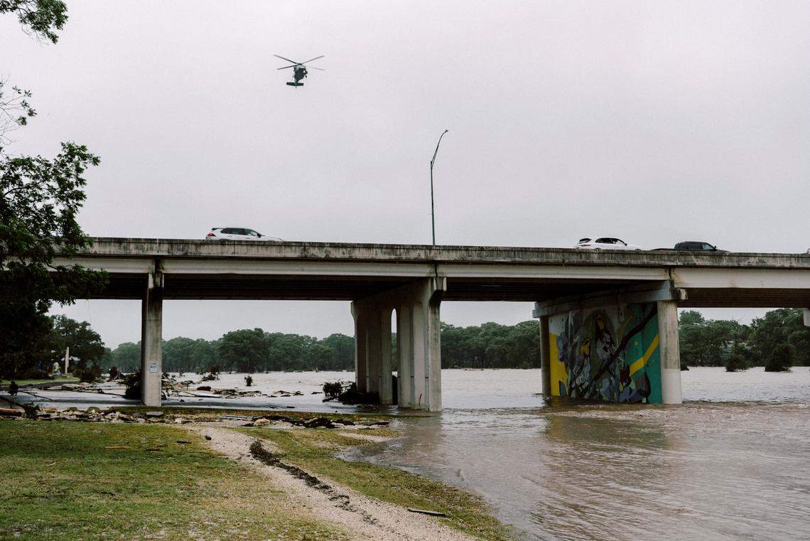 A Blackhawk helicopter makes its way along the flooded Guadalupe River in Kerrville, Texas, on Friday, July 4, 2025, as frantic searches were underway for the missing — many of them children.