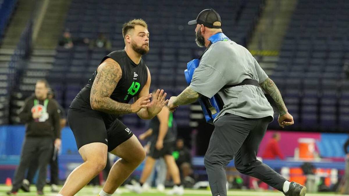  Mar 1, 2026; Indianapolis, IN, USA; Boston College offensive lineman Logan Taylor (OL49) interacts with the Los Angeles Chargers assistant offensive line coach Nick Hardwick during the NFL Scouting Combine at Lucas Oil Stadium. Mandatory Credit: Kirby Lee-Imagn Images | Kirby Lee-Imagn Images 