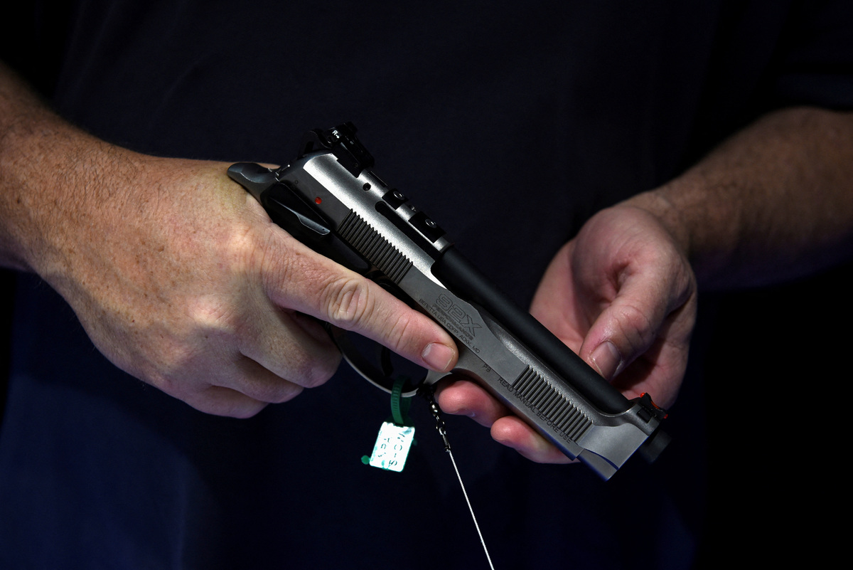FILE PHOTO: An attendee holds a handgun on display at the National Rifle Association (NRA) annual convention in Houston, Texas, U.S. May 29, 2022. REUTERS/Callaghan O'Hare/File Photo
