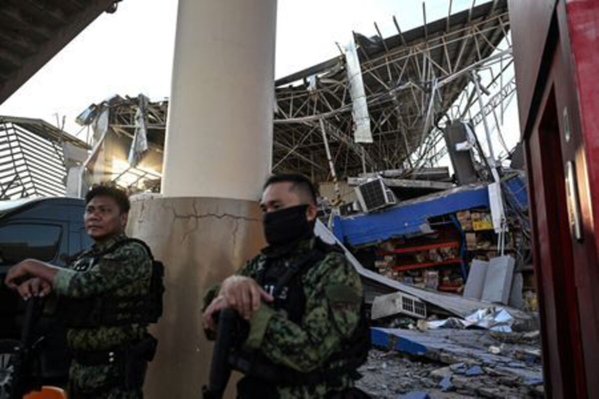 Police officers stand by to secure a collapsed grocery store a day after the magnitude 7.8 earthquake, in Calumpang, General Santos, southern Philippines, June 9, 2026. REUTERS/Noel Celis